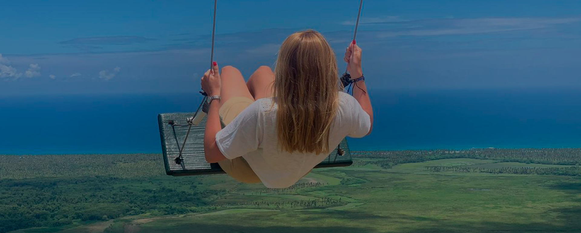 Costa Este mujer en columpio junto al mar