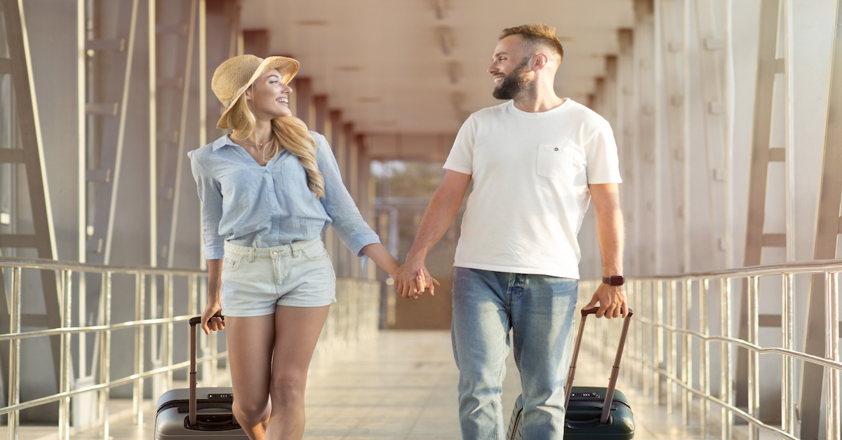 On way to honeymoon. Couple travelers with suitcases pareja de recién casados viajando para disfrutar su luna de miel