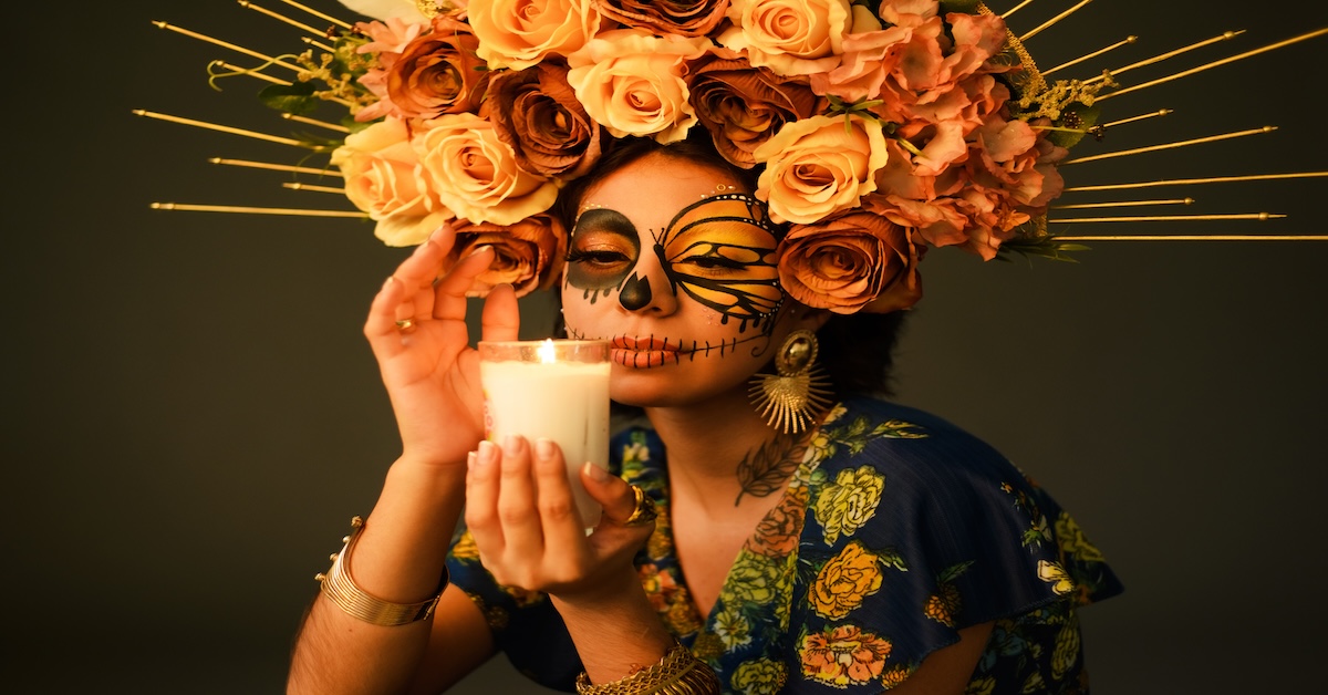 Portrait of a woman with sugar skull makeup. Catrina with butterfly painted on her face. Halloween and day of the dead makeup.